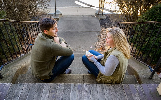 two people talking sitting on outside steps